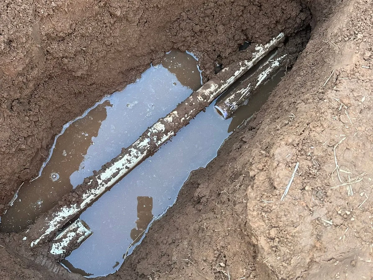 Water pooling in an open trench around a corroded water line in New Mexico