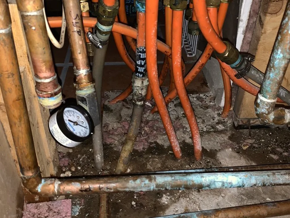 Pressure test gauge fitted to a piping manifold under a house