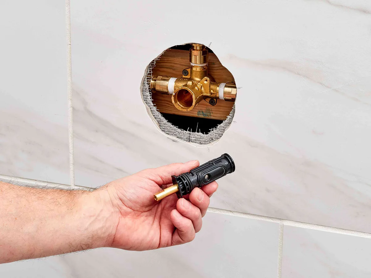 Shower valve opened up in a tiled wall during a repair