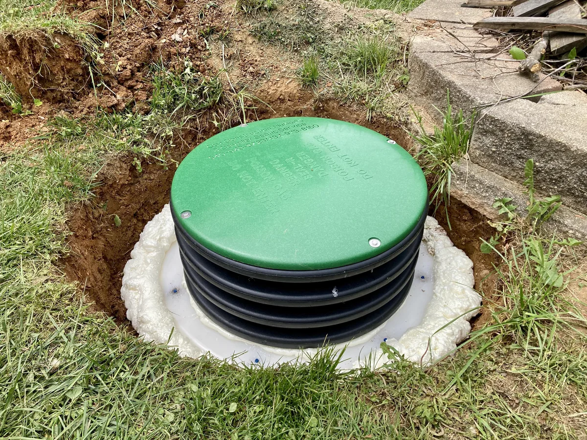 Green septic riser lid set flush in a finished yard