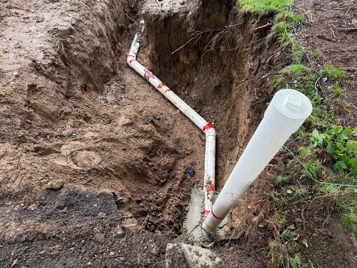 New white PVC sewer pipe laid in an open trench